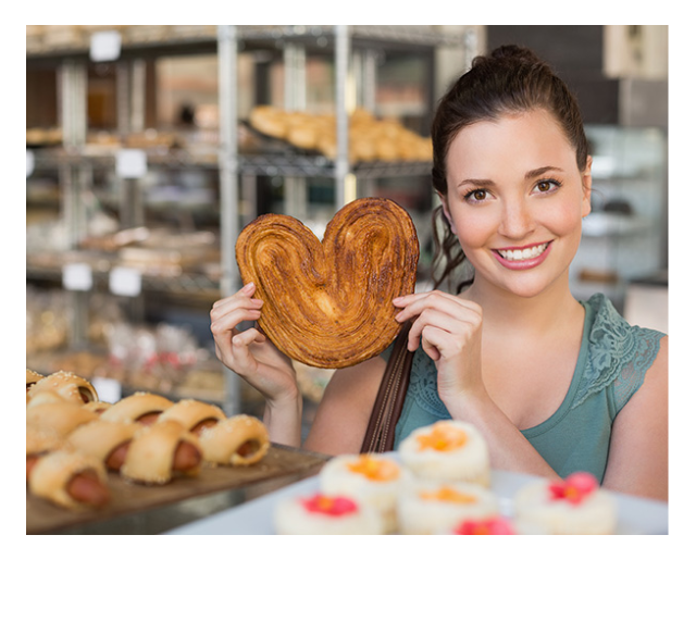 Woman smiling while holding pastry